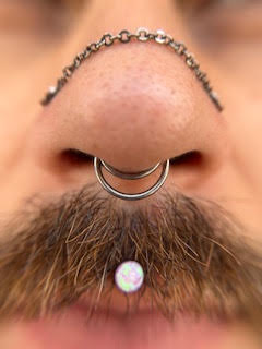 Composição de piercings no nariz e lábio — trabalho de Thaís Muniz